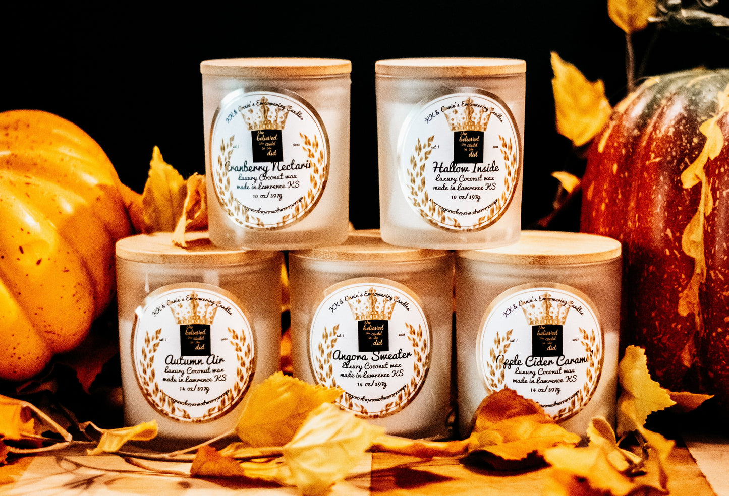 A close-up of the Haunted Library candle in a glass jar in a refined ambiance with a label that says KK & Annie's Empowering Candles, She believed she could so she did, with a golden Queen's crown.