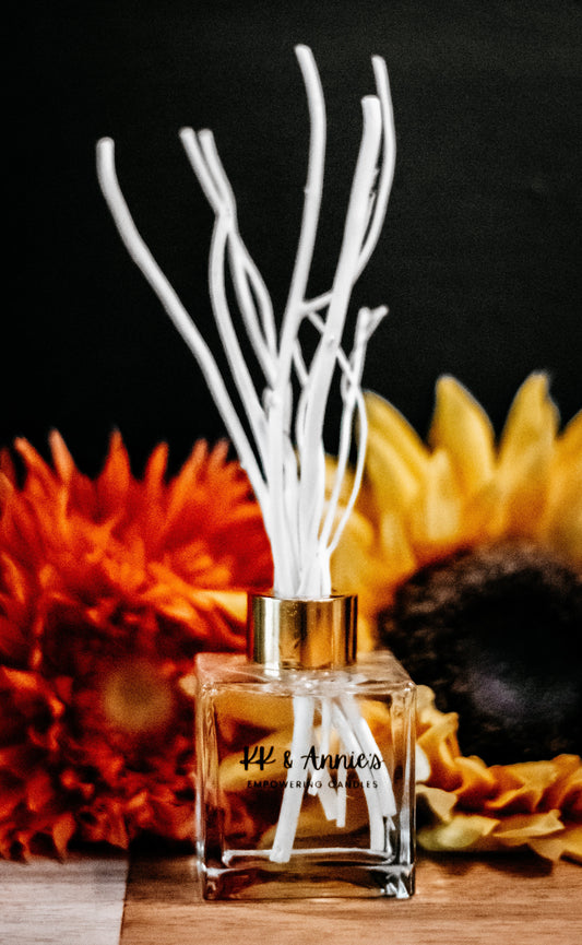 A close-up of the Reed Diffuser bottle, standing elegantly on a wooden surface with reeds emerging from the top exuding a refreshing scent.